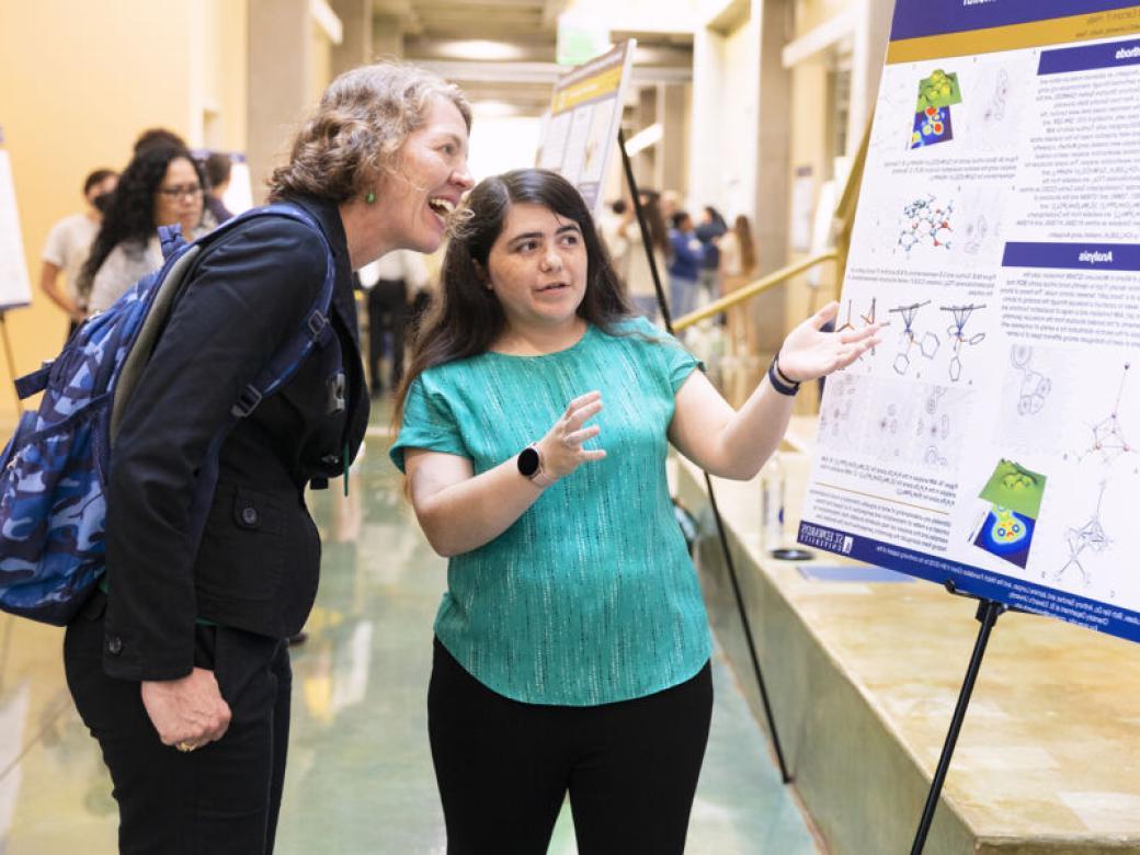 A student presents their research to a guest during the 卢西恩研讨会.