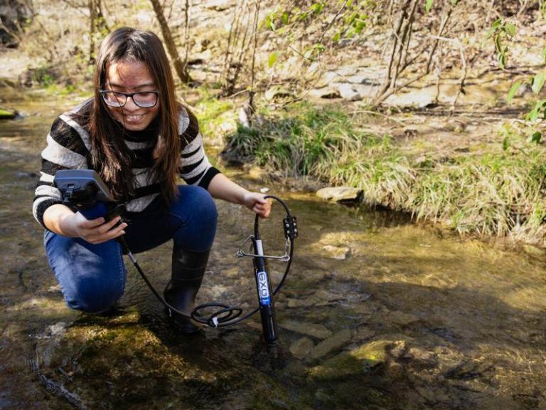 A biology student works in the field