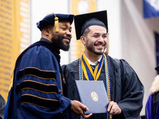 Graduating senior receives diploma at commencement.