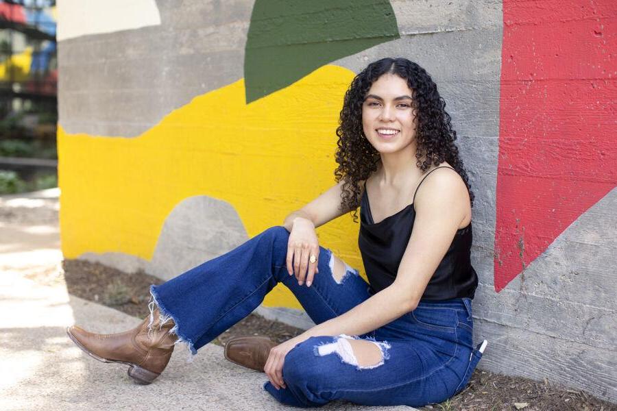 Ruvi Jaimes sits in front of a colorful mural on South Congress Avenue.